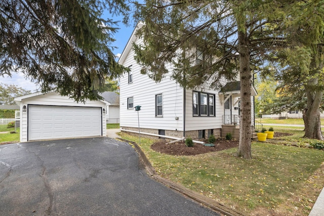 view of front of property with a garage, a front yard, and an outdoor structure