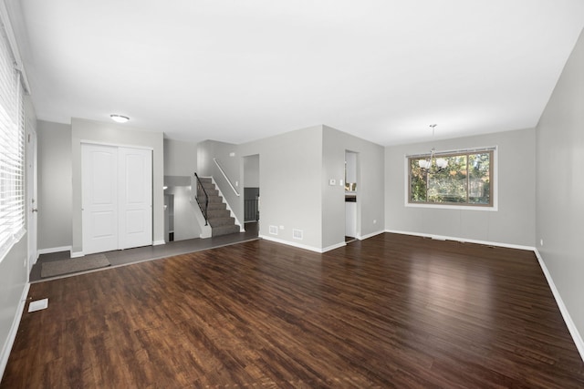 unfurnished living room featuring a chandelier and dark hardwood / wood-style flooring