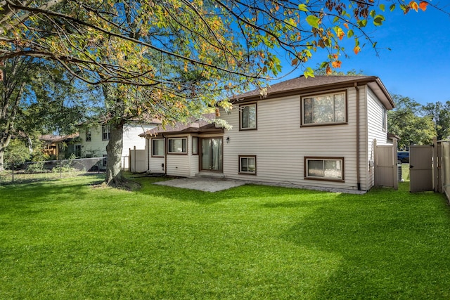 back of house featuring a lawn and a patio