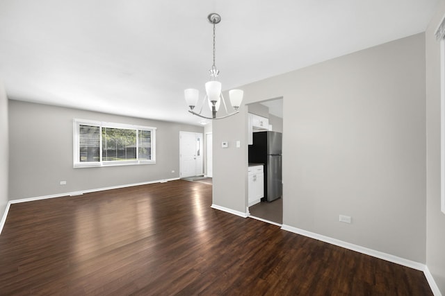 unfurnished dining area with dark wood-type flooring and a notable chandelier