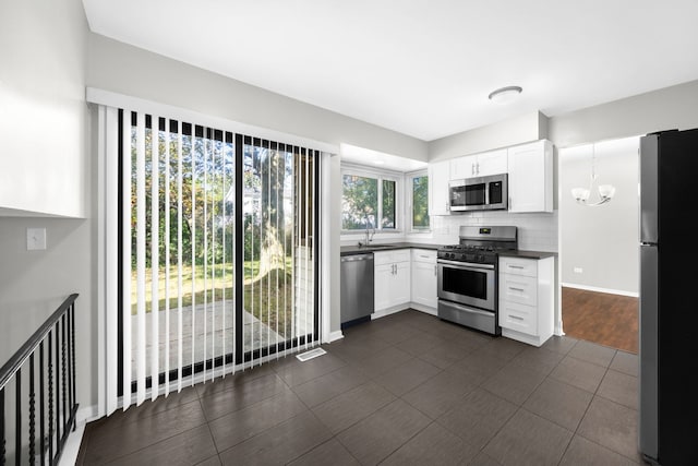 kitchen featuring tasteful backsplash, sink, stainless steel appliances, and white cabinets