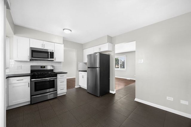 kitchen with decorative backsplash, stainless steel appliances, white cabinets, and dark wood-type flooring