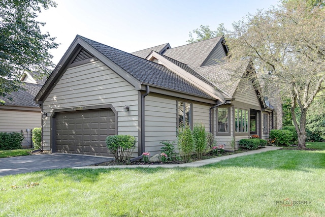 view of side of property featuring a garage and a yard