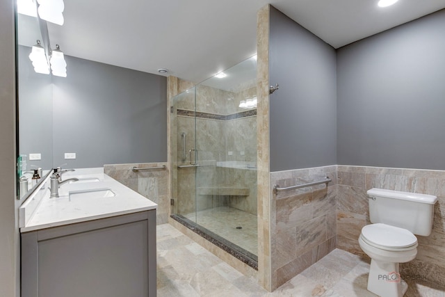 bathroom featuring tile walls, a shower with shower door, vanity, tile patterned flooring, and toilet