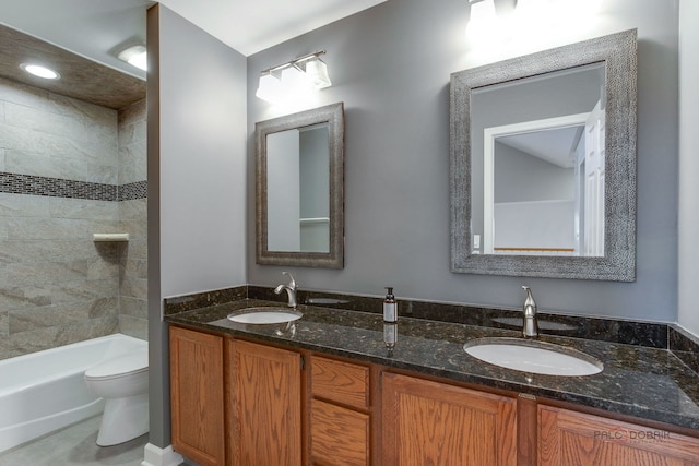 full bathroom featuring tiled shower / bath, vanity, and toilet