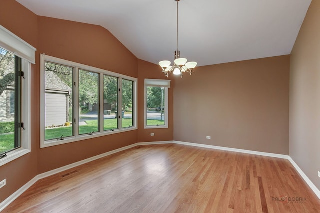 unfurnished room with plenty of natural light, light hardwood / wood-style floors, and a chandelier