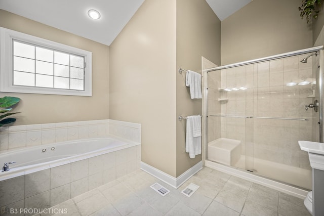 bathroom with tile patterned flooring, vaulted ceiling, and separate shower and tub