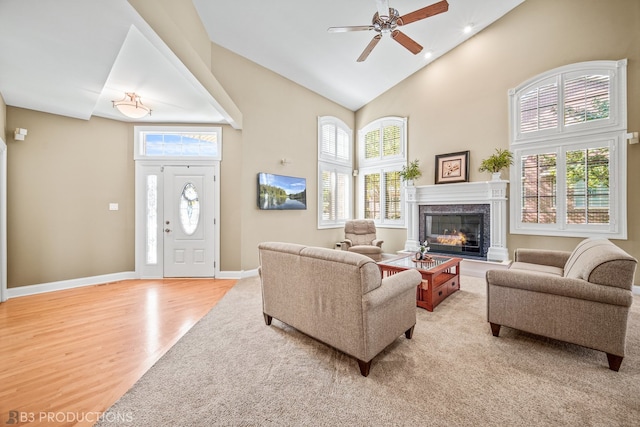 living room with light hardwood / wood-style floors, high vaulted ceiling, and a healthy amount of sunlight