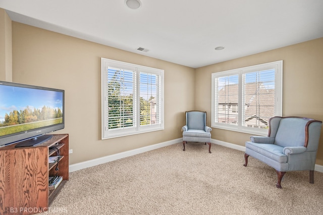 sitting room featuring a healthy amount of sunlight and carpet flooring