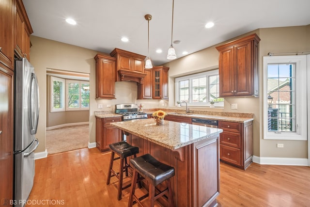 kitchen with a center island, sink, stainless steel appliances, and a wealth of natural light