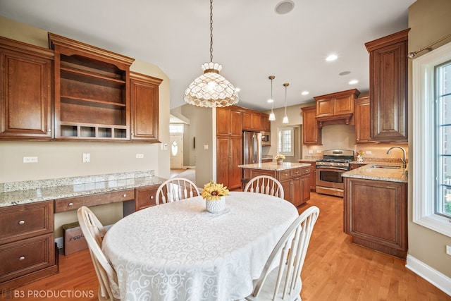 dining room featuring light hardwood / wood-style flooring, sink, and a wealth of natural light