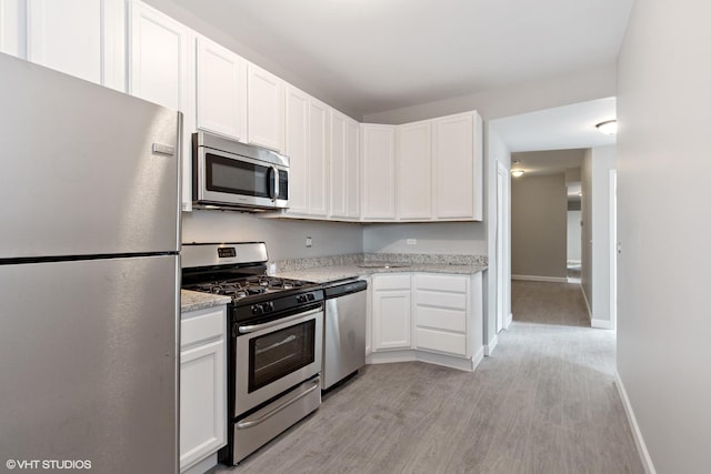 3544 W Douglas Blvd, Chicago, IL 60623 - kitchen featuring stainless steel appliances, light wood finished floors, white cabinetry, and light stone countertops