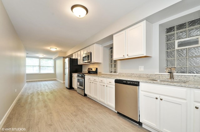 3544 W Douglas Blvd, Chicago, IL 60623 - kitchen featuring appliances with stainless steel finishes, light wood-style flooring, white cabinetry, and light stone counters