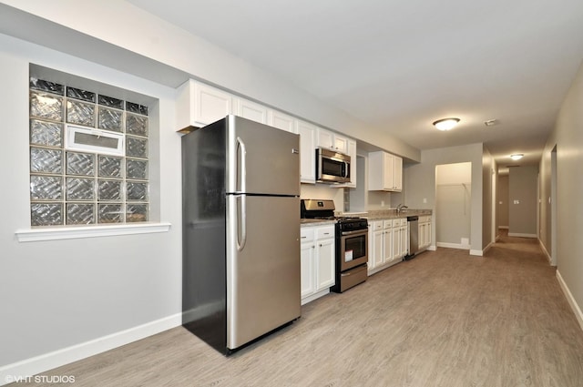 3544 W Douglas Blvd, Chicago, IL 60623 - kitchen featuring appliances with stainless steel finishes, light wood finished floors, white cabinets, and light stone counters