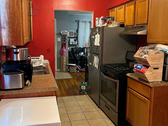 kitchen with stainless steel range with gas cooktop, light hardwood / wood-style floors, and sink