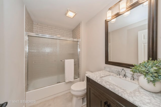 full bathroom featuring combined bath / shower with glass door, vanity, toilet, and tile patterned flooring