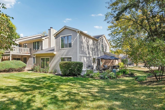 rear view of property with a lawn and a patio