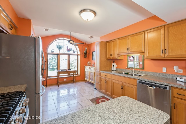 kitchen featuring appliances with stainless steel finishes, vaulted ceiling, light tile patterned floors, ceiling fan, and sink