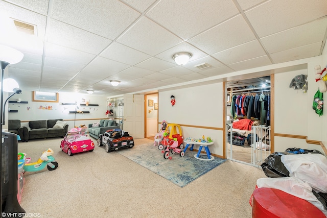 rec room with a paneled ceiling and carpet flooring