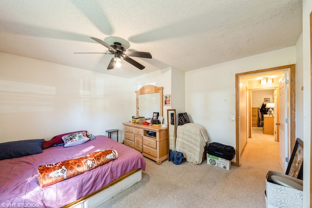 carpeted bedroom featuring a textured ceiling and ceiling fan