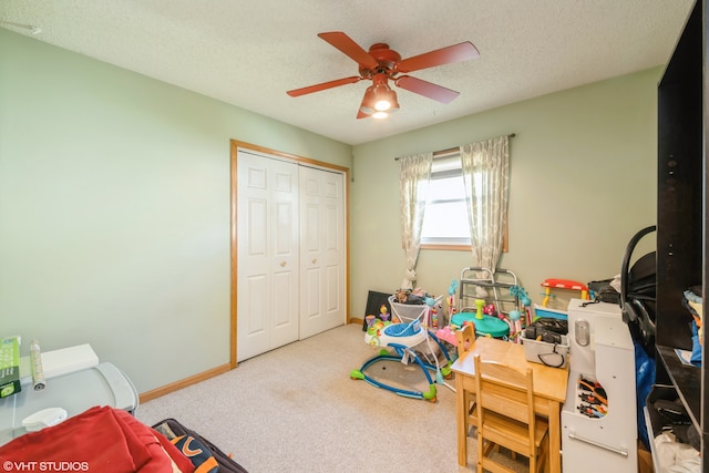 recreation room featuring a textured ceiling, ceiling fan, and carpet floors