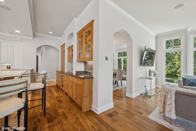 kitchen featuring sink, dark wood-type flooring, crown molding, and tasteful backsplash