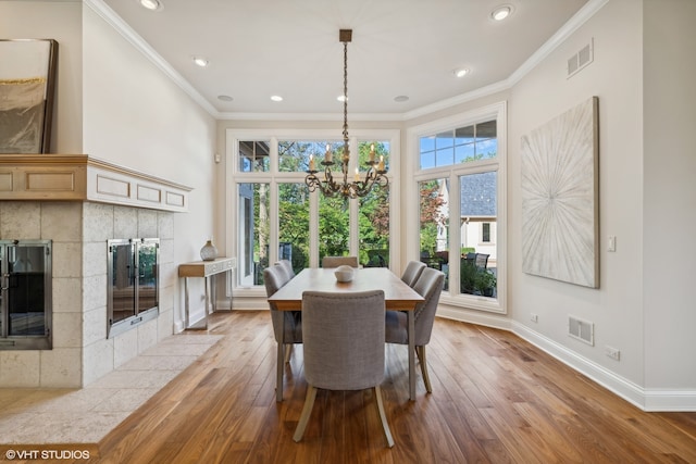 dining area featuring crown molding, light hardwood / wood-style flooring, and an inviting chandelier