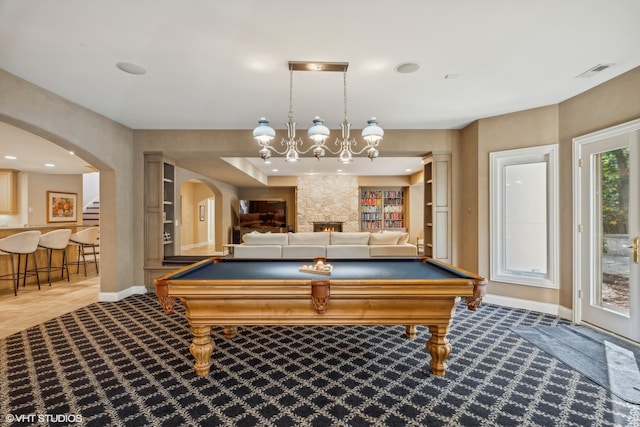 rec room featuring pool table and a stone fireplace