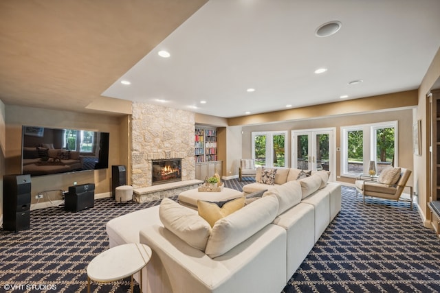 carpeted living room with french doors and a stone fireplace