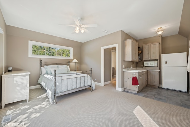 carpeted bedroom with ceiling fan, sink, vaulted ceiling, and white refrigerator