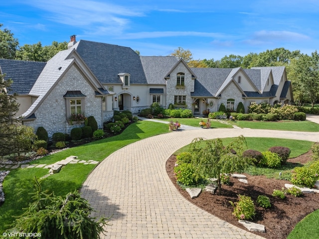 french provincial home with a front yard