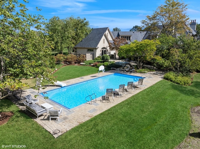 view of pool with a patio area and a lawn