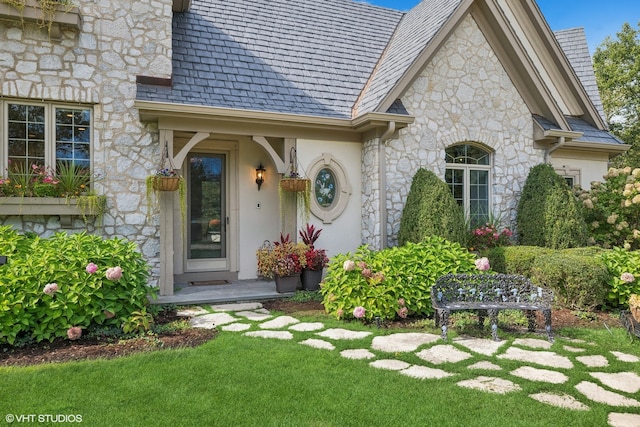 view of exterior entry with a yard