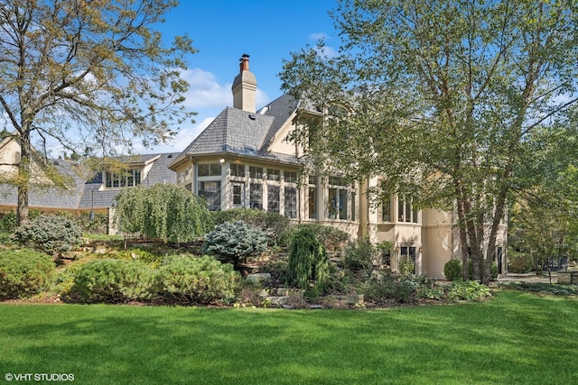 rear view of property with a lawn