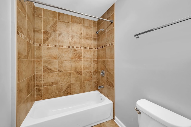 bathroom featuring tiled shower / bath and toilet