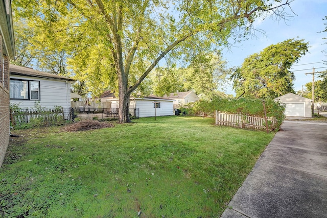 18018 Wentworth Ave, Lansing, IL 60438 - view of yard featuring a detached garage, an outbuilding, concrete driveway, and fence