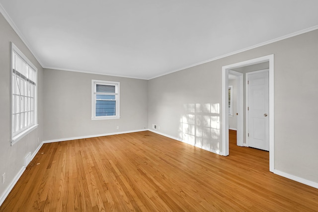 spare room featuring ornamental molding and light hardwood / wood-style flooring