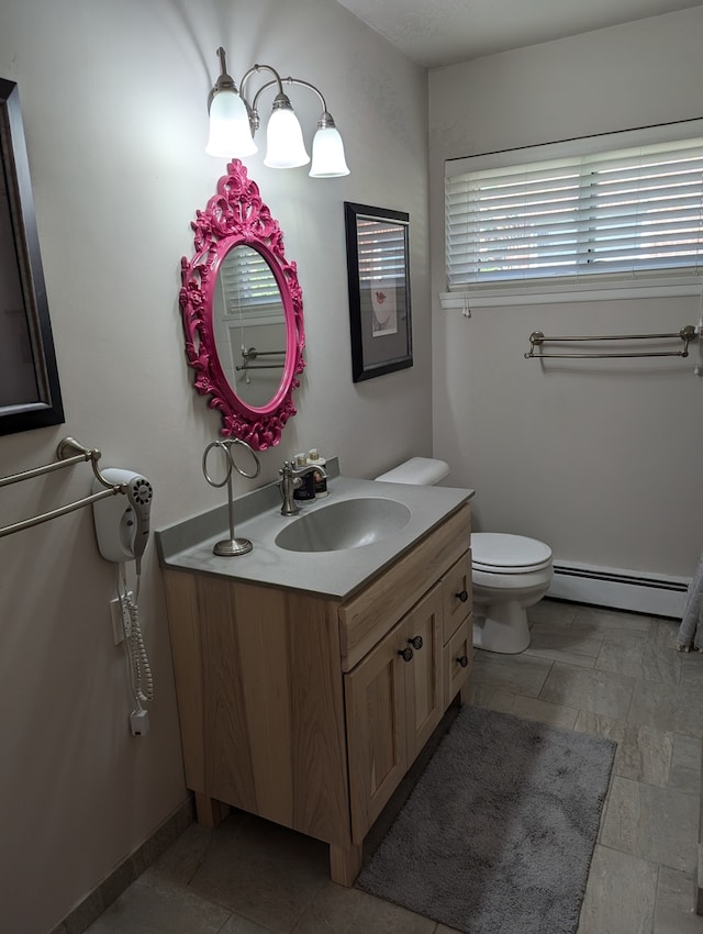 bathroom featuring a baseboard heating unit, vanity, and toilet