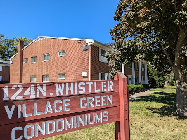 community / neighborhood sign featuring a yard