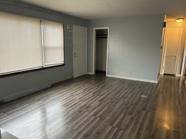 unfurnished bedroom featuring dark wood-type flooring and a baseboard radiator