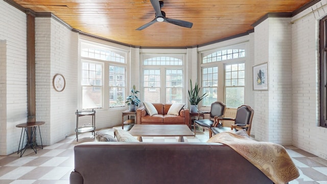 sunroom / solarium with plenty of natural light, wooden ceiling, and ceiling fan