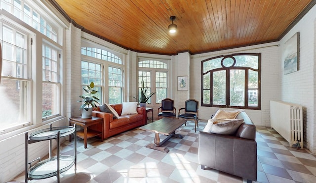 sunroom / solarium featuring wood ceiling, radiator heating unit, and a wealth of natural light