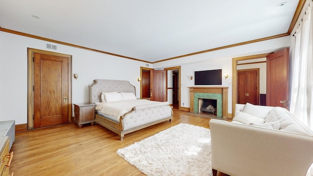 bedroom with ornamental molding and light wood-type flooring