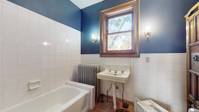 bathroom with radiator, tile walls, tile patterned floors, and a bathtub