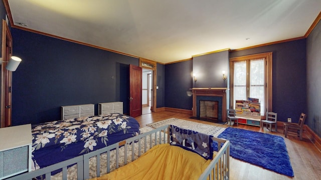 5235 S University Ave, Chicago, IL 60615 - bedroom with wood finished floors, crown molding, a fireplace with flush hearth, and baseboards