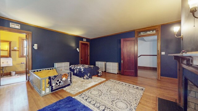 5235 S University Ave, Chicago, IL 60615 - bedroom with wood finished floors, a fireplace with flush hearth, crown molding, baseboards, and ensuite bath
