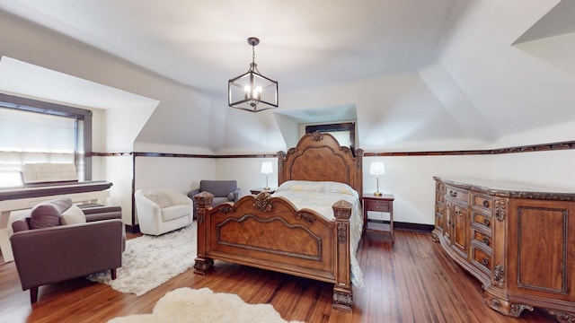 bedroom with dark hardwood / wood-style flooring and an inviting chandelier