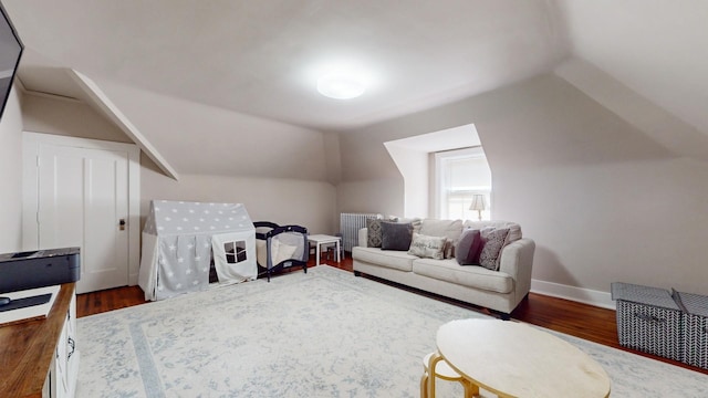 bonus room featuring lofted ceiling, radiator heating unit, and dark hardwood / wood-style floors