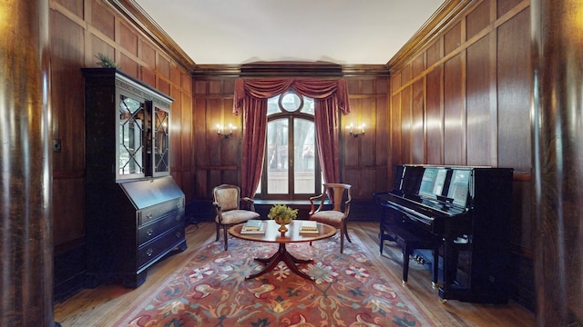 living area with crown molding, wood-type flooring, and wood walls