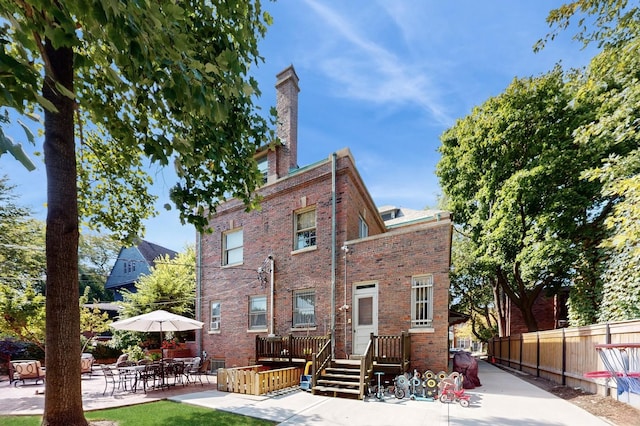 5235 S University Ave, Chicago, IL 60615 - view of front of home with a patio area, brick siding, and a chimney